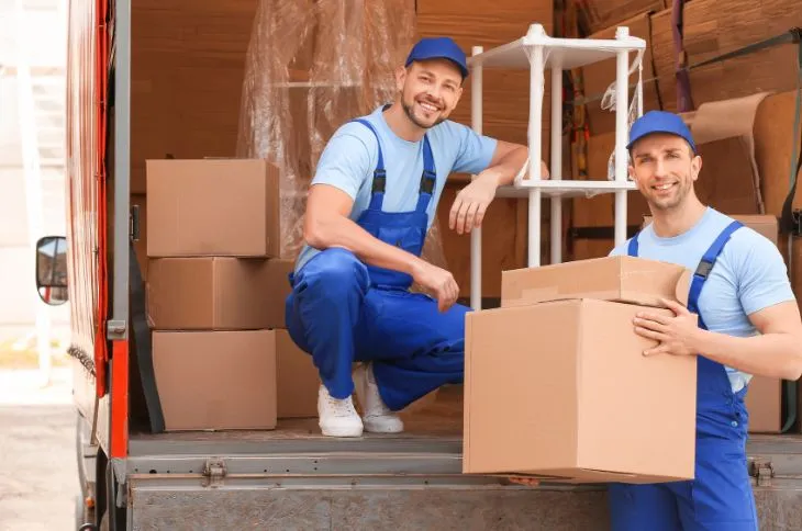 Möbelpacker tragen Kartons aus LKW